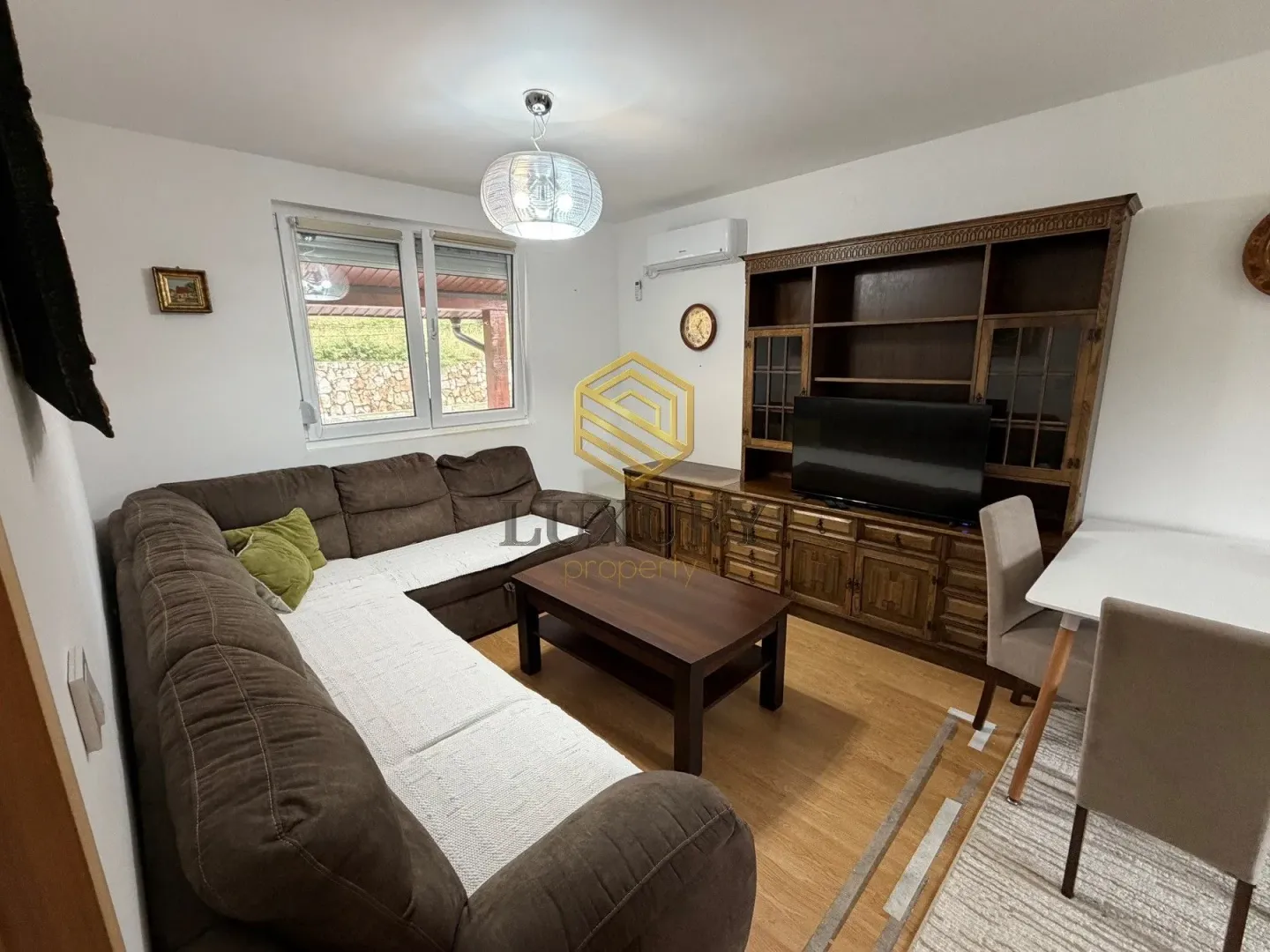 Living room with a sofa, wooden furniture, and a dining table.