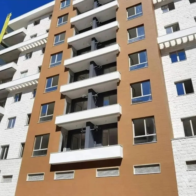 Pogled na modernu fasadu višestambene zgrade sa terasama.