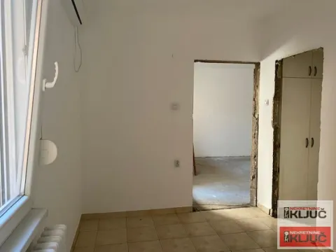 Prazna prostorija sa popločanim podom i vratima koja vode u drugu prostoriju. - image 4