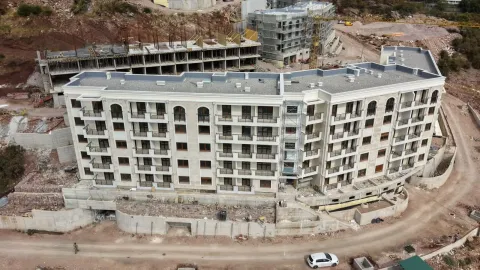 Pogled iz vazduha na višestambenu zgradu u izgradnji sa uređenom fasadom i terasama. - image 2