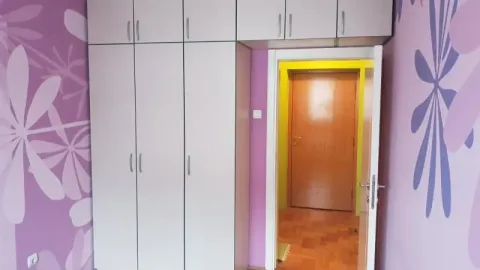 Spavaća soba sa velikim ugradnim garderoberom i ljubičastim tapetama sa cvetnim motivima. - image 14