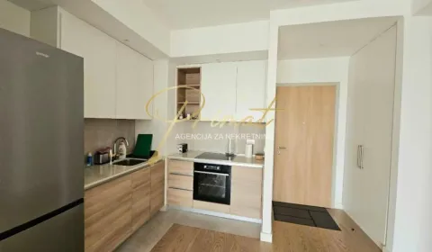 Modern kitchen with built-in appliances and a refrigerator. - image 3