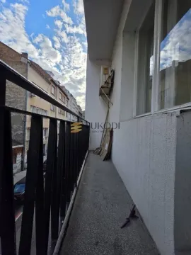 Long balcony with metal railing and street view. - image 11