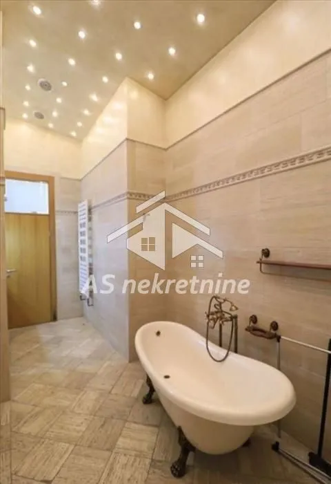 Bathroom tiled in ceramic with a classic clawfoot bathtub.