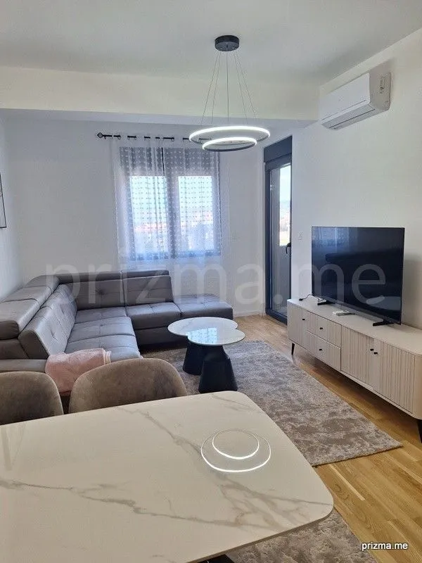 Living room with a sofa, TV, and dining table.