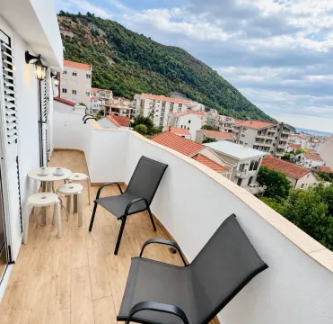 Balkon sa garniturom za sjedenje i pogledom na grad i brdo. - image 7