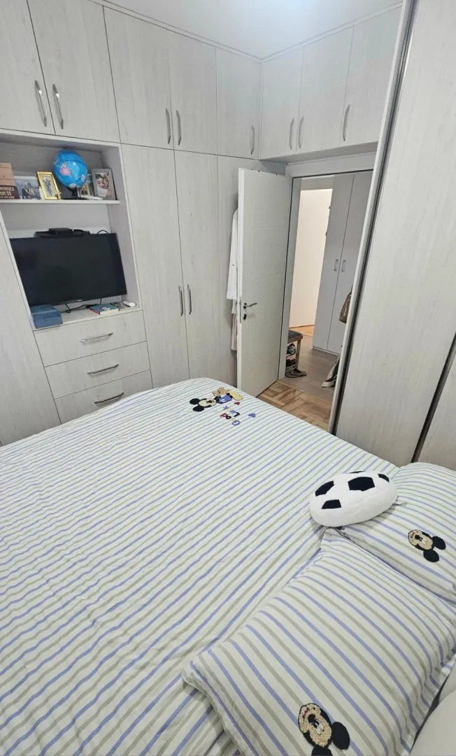 Namještena spavaća soba sa ugradnim plakarima i bračnim krevetom.