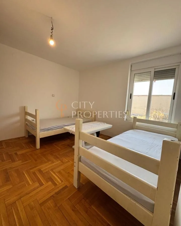 Bedroom with two wooden beds and parquet flooring.