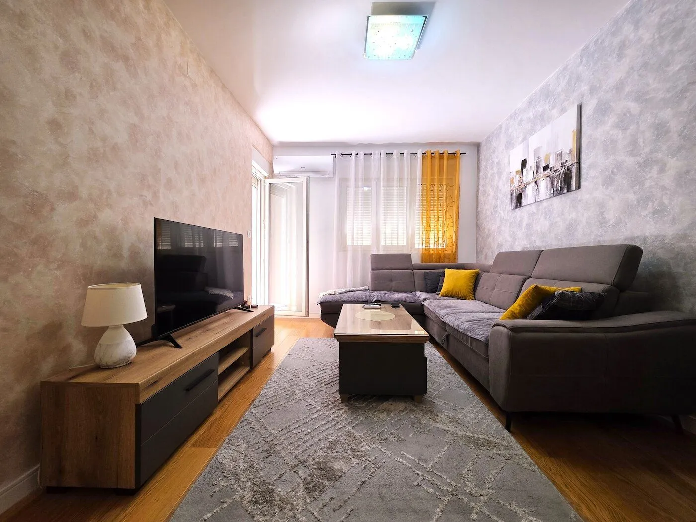 Living room with a sectional sofa, TV, and media console.