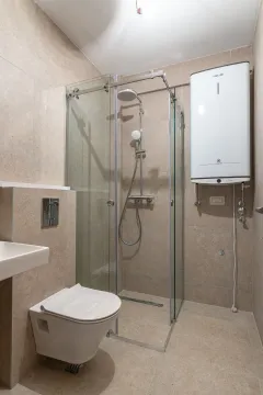 Kupatilo opremljeno tuš kabinom, WC šoljom, umivaonikom i bojlerom. - image 3