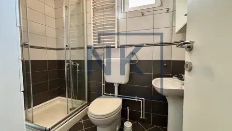 Bathroom equipped with a shower cabin, washbasin, and toilet. - image 15