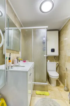 Manje kupatilo sa tuš kabinom, umivaonikom i wc šoljom obloženo keramičkim pločicama. - image 7