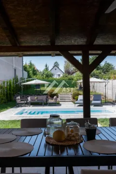 Pogled iz natkrivene terase na dvorište sa bazenom i ležaljkama. - image 9