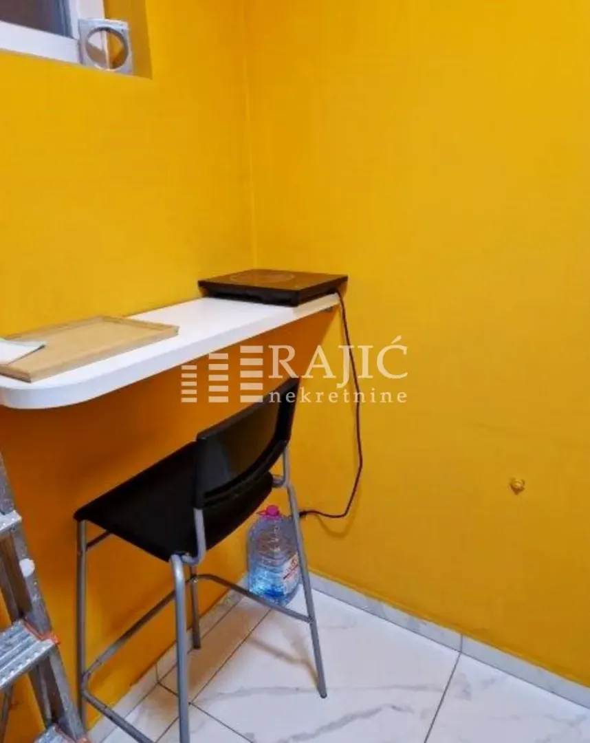 Smaller kitchen with a bar counter and yellow walls.