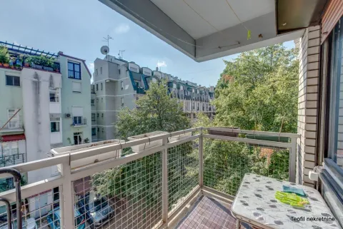 View from the balcony overlooking surrounding buildings and trees. - image 7