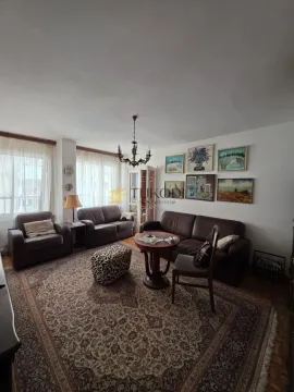 Dnevna soba sa garniturom za sedenje, tepihom i umetničkim slikama na zidu. - image 8