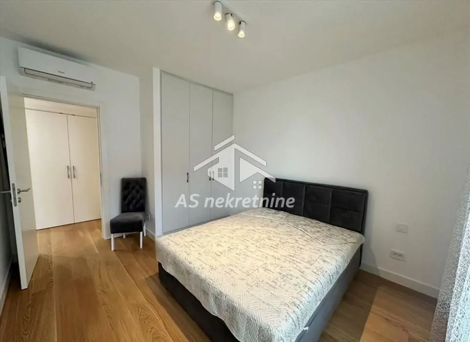 Bedroom with a double bed, built-in wardrobe, and hardwood flooring.