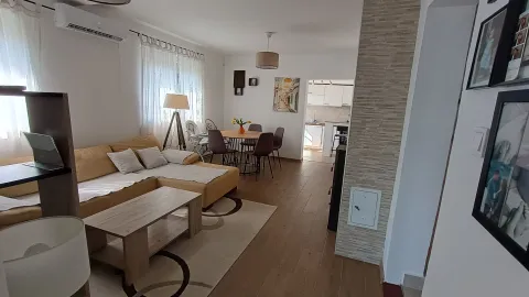 Dnevna soba sa ugaonom garniturom, stočićem i trpezarijom u pozadini. - image 2