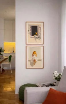 Living room with a sofa and paintings on the wall. - image 11