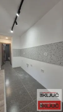 Prazan prostor predviđen za kuhinju sa keramičkim pločicama na zidu i podu. - image 4