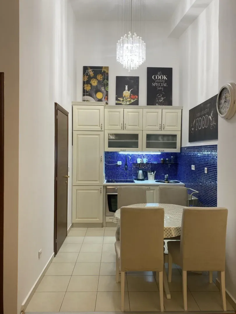 Bright kitchen with a dining table and blue tiles.