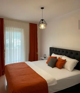 Comfortable bedroom with a large double bed, orange details and access to the terrace. - image 4