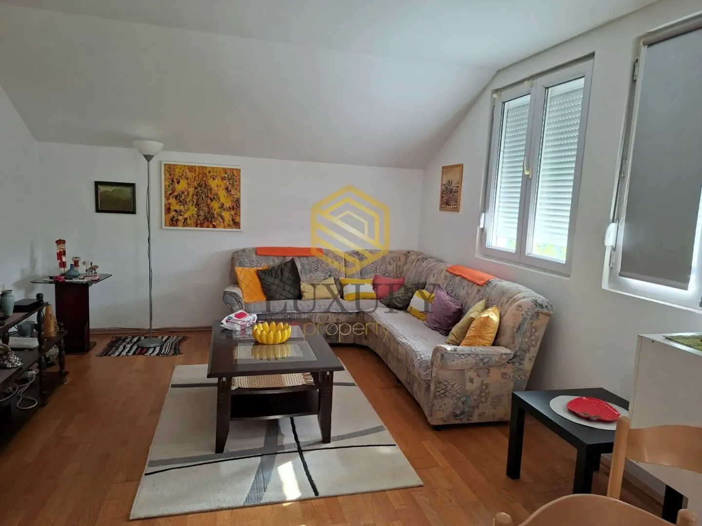 Spacious living room with a corner sofa, coffee table, and windows.
