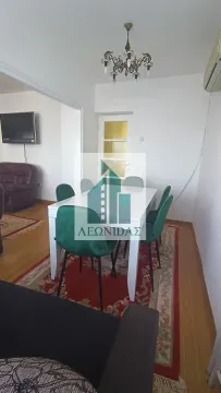 Dining area connected to the living room with a dining table and green chairs. - image 3