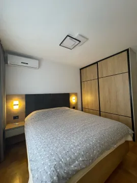 Furnished bedroom with a double bed, fitted wardrobe, and air conditioning unit. - image 12