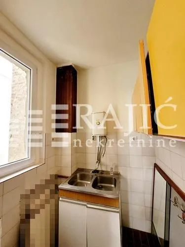 Smaller kitchen with a sink, water heater, and kitchen elements in the interior.