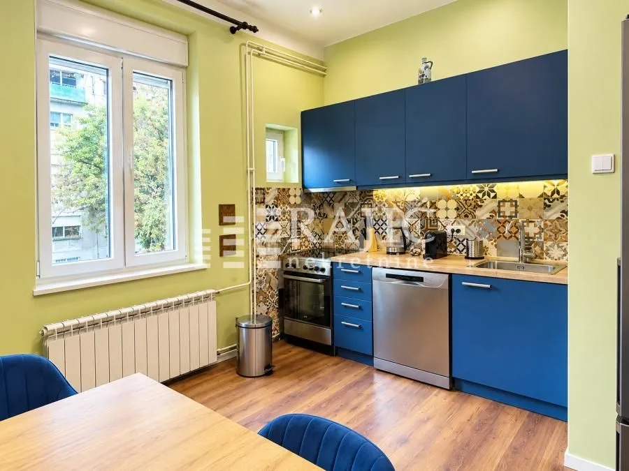Modern kitchen with blue cabinetry and a dining table.