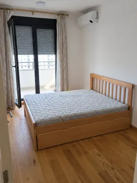 Bedroom with a wooden bed and access to the terrace. - image 4