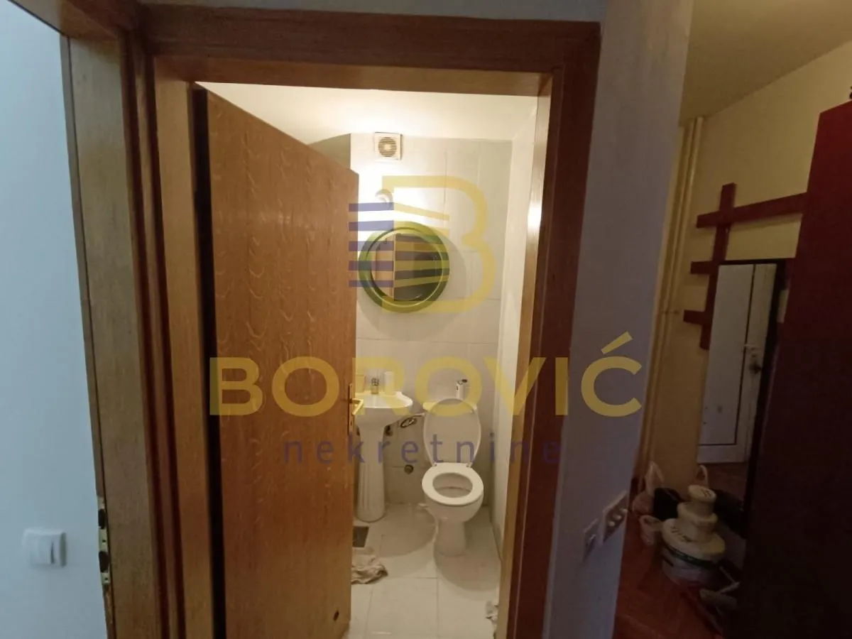 Pogled kroz otvorena vrata na manje kupatilo sa sanitarijama.