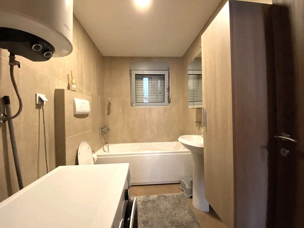 Fully equipped bathroom with a bathtub, sink, and washing machine.