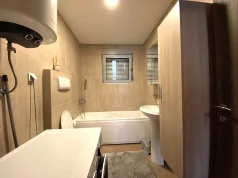 Fully equipped bathroom with a bathtub, sink, and washing machine. - image 7