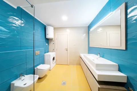 Moderne kupatilo sa plavim i bež pločicama, velikim ogledalom i veš mašinom. - image 11