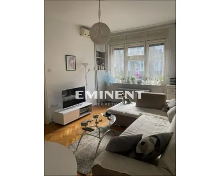Living room with a sofa, TV, and a large window. - image 9