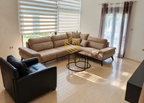 Spacious living room with a sectional sofa, armchair, and large windows. - image 17