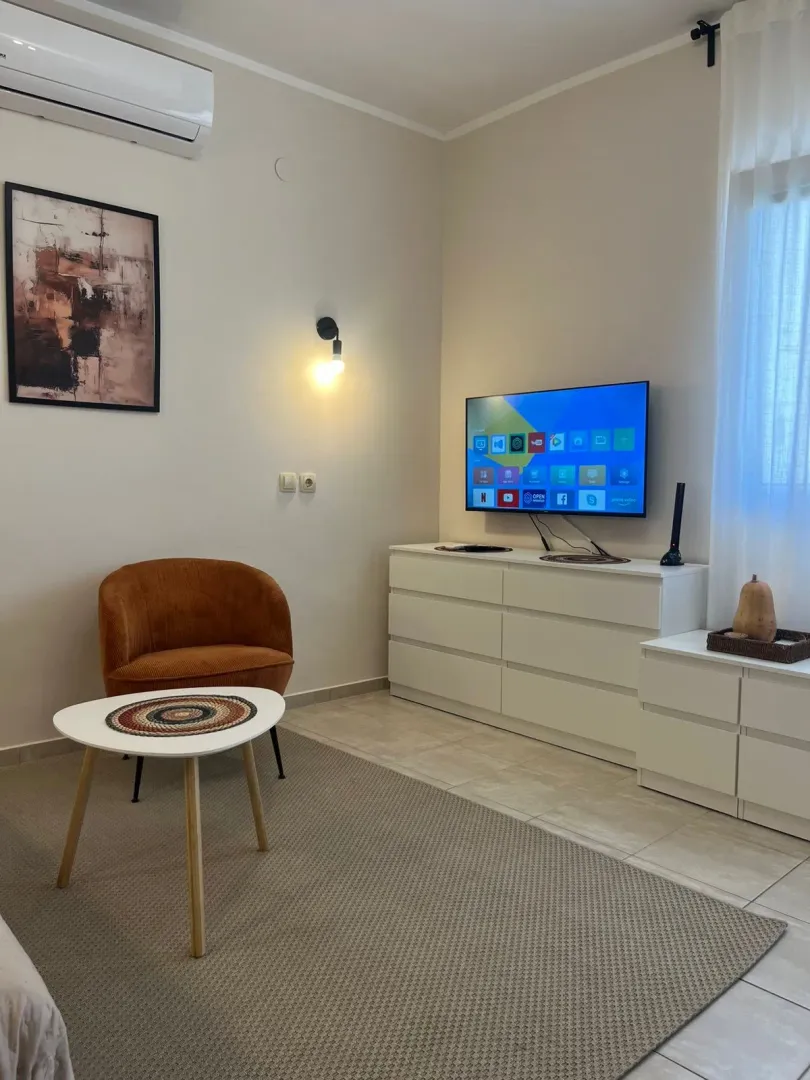 Decorated living room with an armchair, dresser, and television.