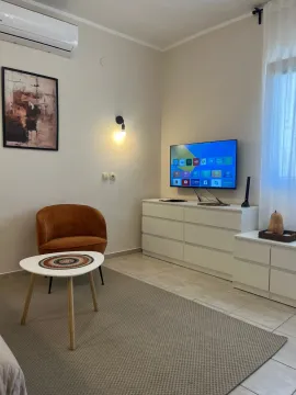 Decorated living room with an armchair, dresser, and television. - image 2