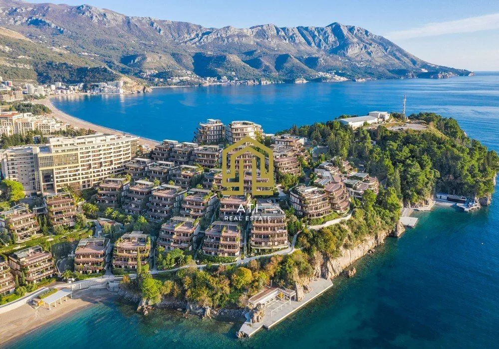 Pogled iz vazduha na hotelski kompleks na obali mora sa planinskim zaleđem.