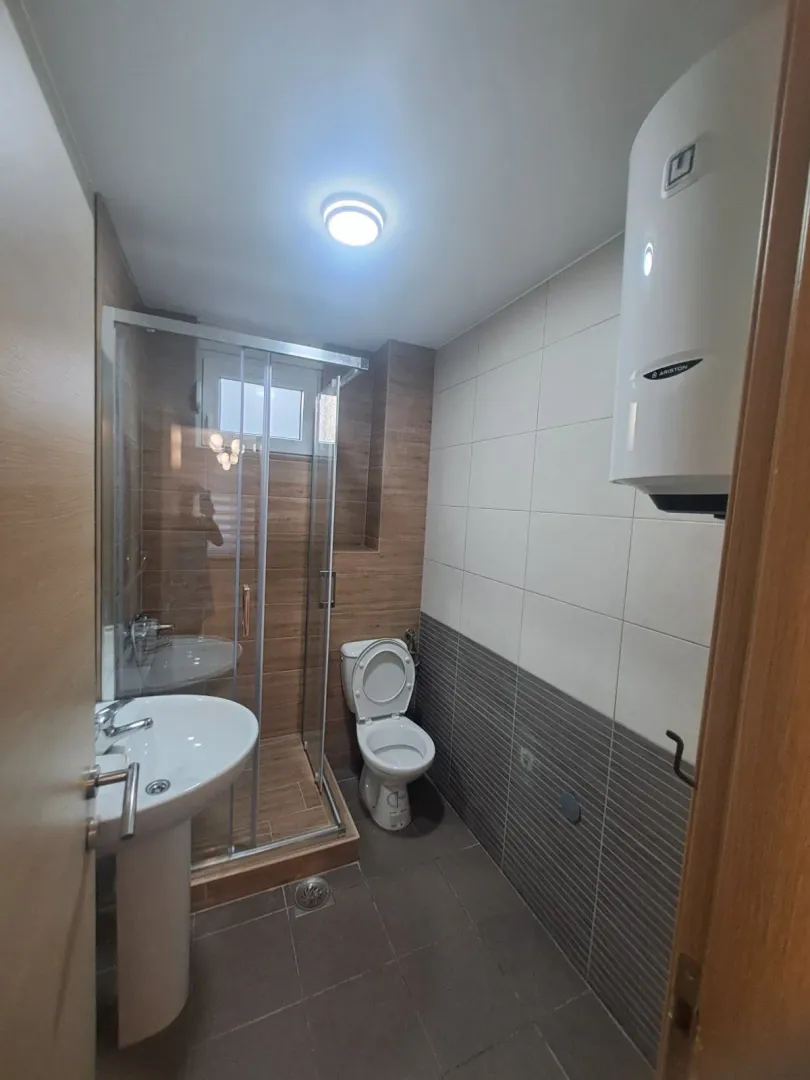 Bathroom equipped with a washbasin, toilet, shower cabin, and water heater.