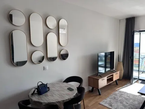 Living room with a dining table and decorative wall mirrors. - image 2