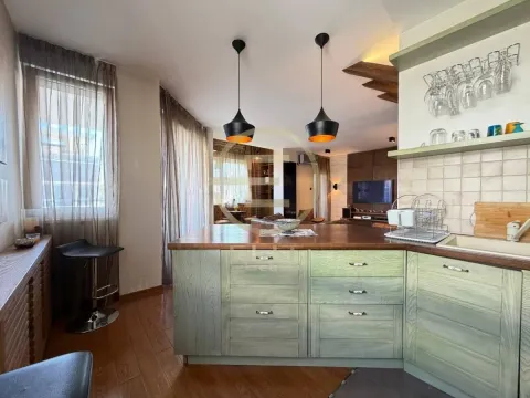 Moderna kuhinja sa drvenim elementima i šankom, povezana sa dnevnim boravkom. - image 16