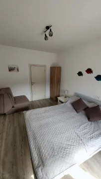 Namještena spavaća soba sa bračnim krevetom, foteljom i ormarom. - image 6