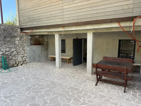 Dvorište sa popločanim platoom i drvenom garniturom u prizemlju kuće. - image 12