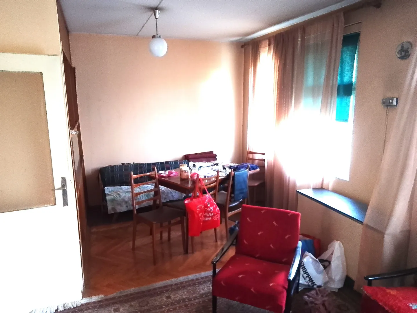 Dnevna soba sa garniturom, trpezarijskim stolom i stolicama.