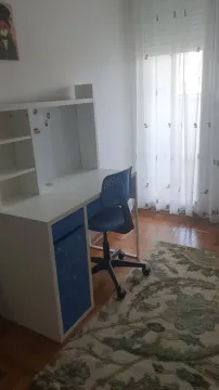 A study corner with a white desk and a blue chair next to the window. - image 13