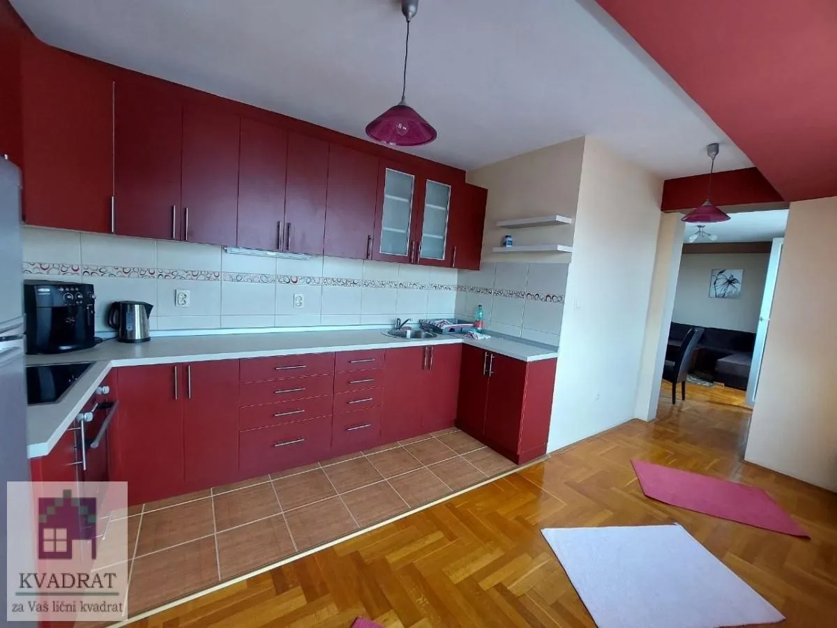 Kitchen with red cabinetry and parquet flooring.