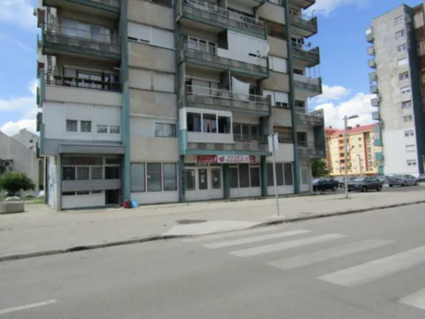 Exterior view of a residential building with commercial space on the ground floor.